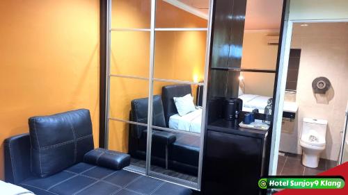 クランにあるHotel Sunjoy9 Klangの鏡と椅子、トイレが備わる客室です。