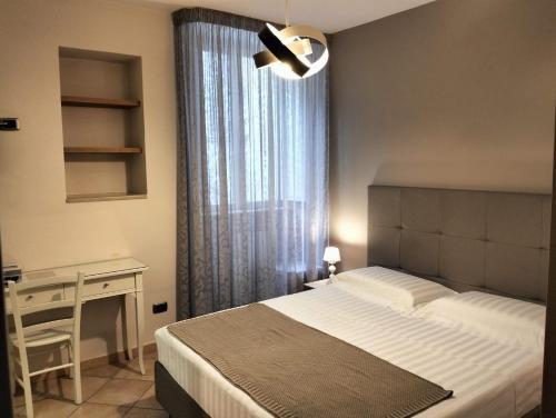 a bedroom with a bed and a desk and a window at Bed & Breakfast De Nittis in Barletta