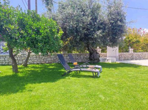 a chair sitting in the grass in a yard at Rhodes Soul luxury suites in Afantou