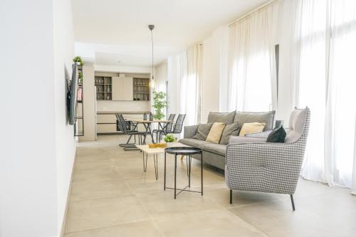 uma sala de estar com um sofá, cadeiras e uma mesa em Moott Homes Suites Casa de los Leones APTO 1 em Almeria