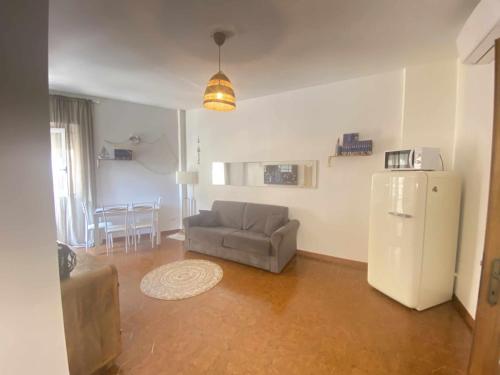 een woonkamer met een bank en een koelkast bij Seamoon Home Nettuno in Nettuno