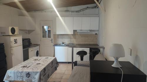 une cuisine avec des armoires blanches et un comptoir noir dans l'établissement Studio charmant, à Fontenay-sous-Bois