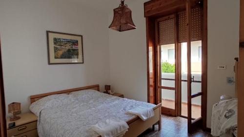sypialnia z łóżkiem i przesuwnymi szklanymi drzwiami w obiekcie Przystań Adriatyk Świetna Lokalizacja w mieście Torre dell'Orso