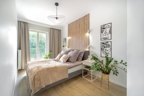 a white bedroom with a bed and a desk at Apartament Kameralis Old Town - klimatyzacja - balkon - winda in Elblag