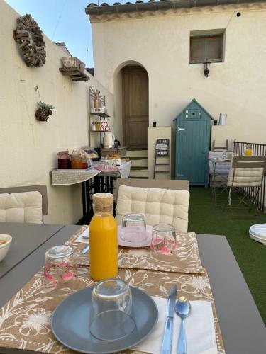 a table with a bottle of orange juice on it at Ô 36 Rempart Sud B&B in Aigues-Mortes