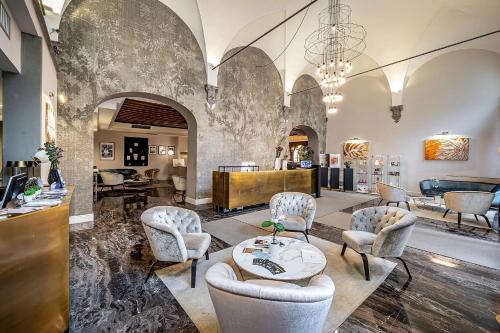 a lobby with chairs and a table and a salon at Palazzo Alfieri Residenza D'Epoca - Alfieri Collezione in Florence