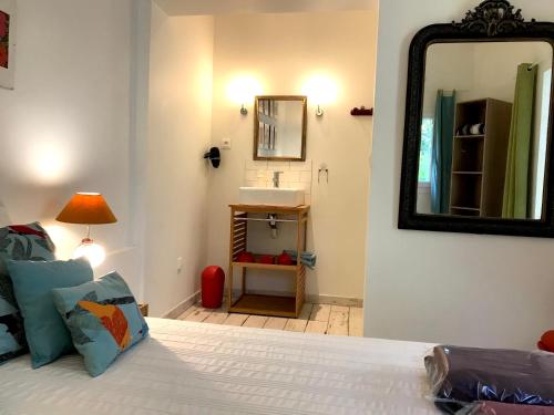 - une chambre avec un lit, un miroir et un lavabo dans l'établissement VILLA DU GOLFE - Studio Saint Jean, à La Ciotat