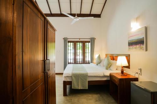 漢班托塔的住宿－Malala Retreat，一间卧室设有一张床和一个窗口