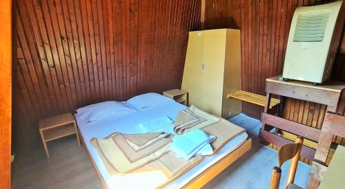 a small bedroom with a bed and a wooden wall at FKK Ada Bojana in Ulcinj