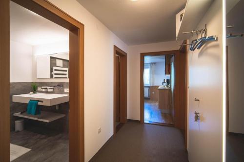 ein Bad mit einem Waschbecken und einem Spiegel in der Unterkunft Alpenherz Apartments in Sankt Gallenkirch