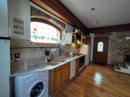 Zografia cottage في Lámpou Mýloi: مطبخ مع غسالة ومغسلة