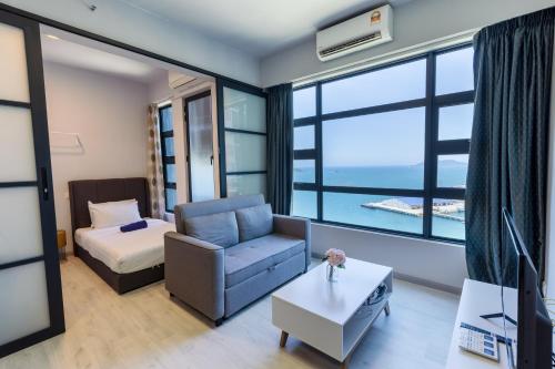 a living room with a couch and a bed and window at Margo Home - Jesselton Quay in Kota Kinabalu