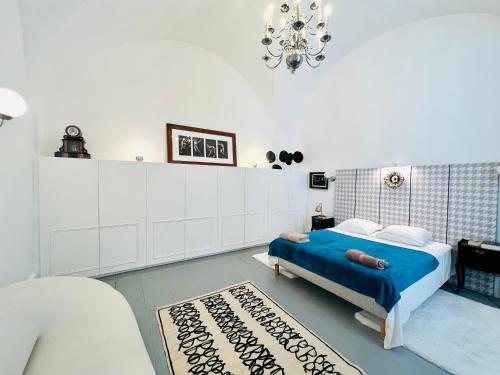 una camera bianca con un letto blu e un lampadario a braccio di Courbet's bachelor pad a Montpellier