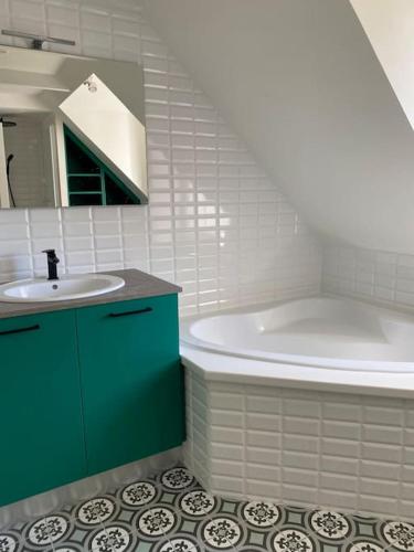 une salle de bain avec une baignoire et un lavabo et une baignoire dans l'établissement Belle longère au calme, à Carantec