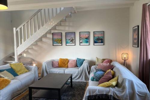 - un salon avec deux canapés et un escalier dans l'établissement Belle longère au calme, à Carantec