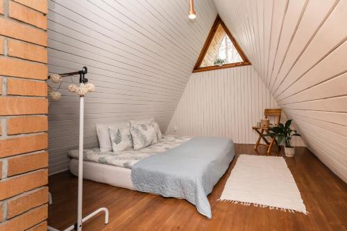 1 dormitorio con 1 cama en el ático en Maro Guesthouse with Sauna en Vääna-Jõesuu