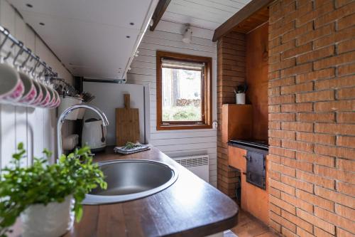 cocina con fregadero y pared de ladrillo en Maro Guesthouse with Sauna en Vääna-Jõesuu