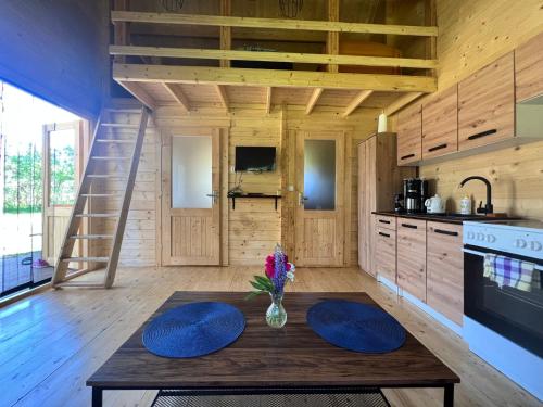 a kitchen with a table with a vase of flowers on it at Domek w lesie na Mazurach in Orzyny