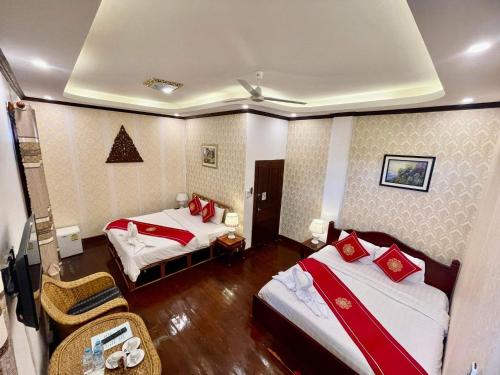 a hotel room with two beds with red pillows at Villa Phathana Royal View Hotel in Luang Prabang