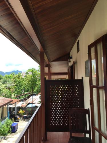 a balcony with a wooden fence and a chair at Le KhounSok Boutique Hotel in Luang Prabang