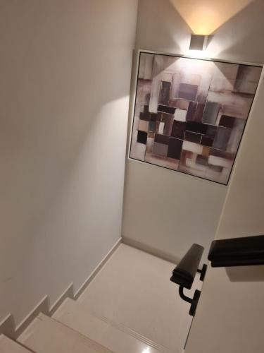 un escalier dans une pièce avec une photo sur le mur dans l'établissement brand new villa, à Dubaï