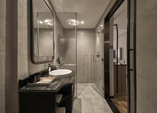 a bathroom with a sink and a glass shower at La Siesta Premium Saigon in Ho Chi Minh City