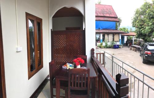 a porch with a table and chairs on a balcony at Le KhounSok Boutique Hotel in Luang Prabang