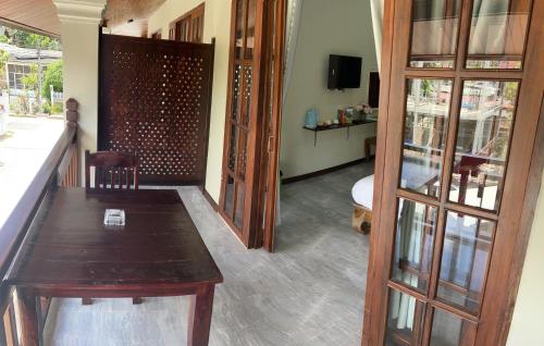 a room with a wooden table and some glass doors at Le KhounSok Boutique Hotel in Luang Prabang