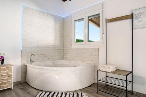 baño blanco con bañera y ventana en La Teja 3, en Vejer de la Frontera