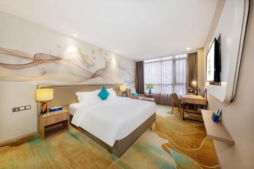 a hotel room with a bed and a desk at Qianhai Holiday Hotel in Bao'an