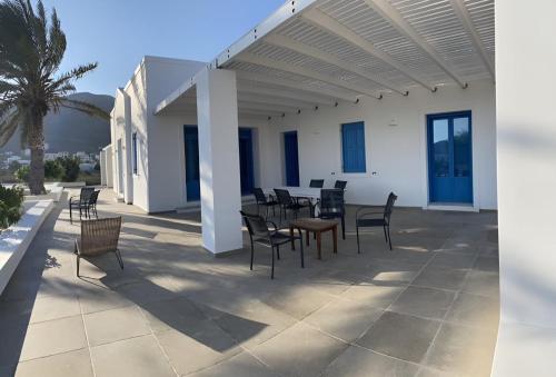 a patio with chairs and tables and a white building at Villa on the beach, Sarpakis Villa in Tzamaria