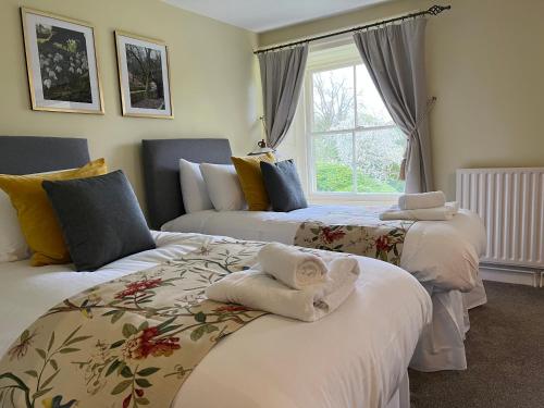 a bedroom with two beds with towels on them at Lovelady Shield Country House Hotel in Alston