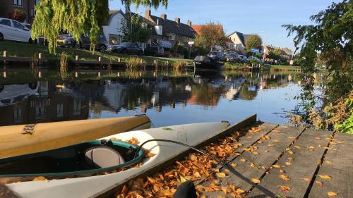 a boat tied up to a dock on a river at Bennebroek B&B in Bennebroek