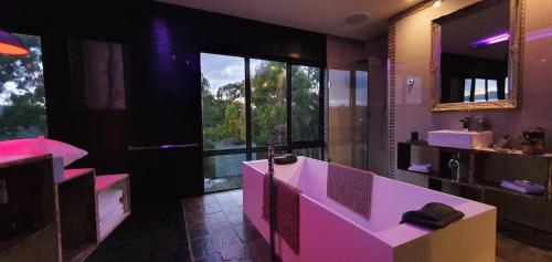 a bathroom with a pink tub and a large window at Rehab155 @Destination M: relax, reconnect, imagine in Lower Gellibrand