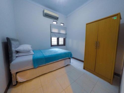 a bedroom with a bed and a yellow cabinet at Sukasari Guesthouse in Tasikmalaya