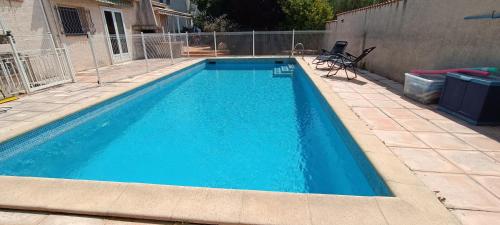 a swimming pool with blue water in a yard at Grand Duplex DANS villa familiale 3CH 7 PERS JARDIN, PISCINE in Juvignac