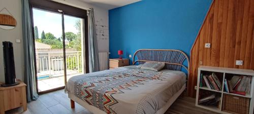 a bedroom with a bed with a blue wall at Grand Duplex DANS villa familiale 3CH 7 PERS JARDIN, PISCINE in Juvignac
