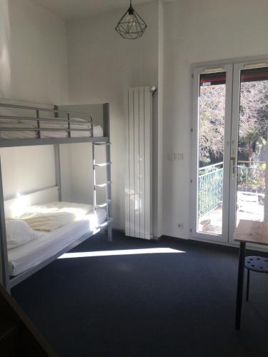 - une chambre avec des lits superposés et un balcon dans l'établissement Ethic étapes le Cart, à Sommières