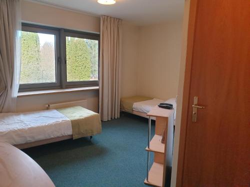 Habitación de hotel con 2 camas y ventana en Apartament nad zalewem en Serock