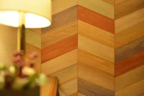 a wood paneled wall with a table and a lamp at Hotel New Gaea Itoshima in Itoshima