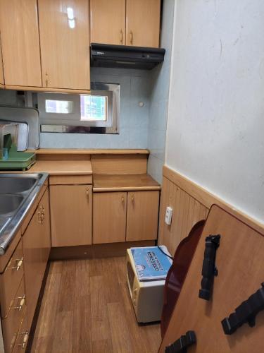 a small kitchen with wooden cabinets and a counter top at JNW MINBAK in Damyang