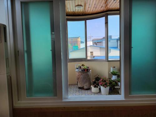 a window with three potted plants in a room at JNW MINBAK in Damyang