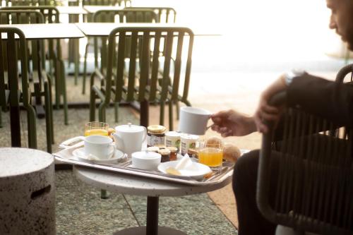 a tray of food on a table with cups and drinks at Kyriad Prestige Hotel Clermont-Ferrand in Clermont-Ferrand