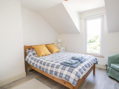 a white bedroom with a bed and a window at Pow-Wow Shore Cottage in Annan