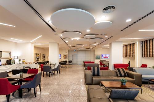 a waiting room with couches and tables at Benjamin Business Hotel in Herzelia 