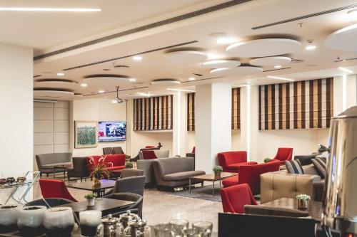 a salon with red chairs and a waiting room at Benjamin Business Hotel in Herzelia 