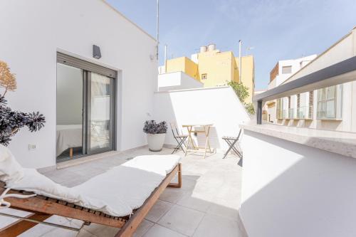 a balcony with a couch and chairs on a building at Moott Homes Suites Casa de los Leones APTO 2 in Almería
