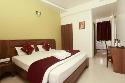 a bedroom with a large bed with red and white pillows at Hotel Metropolitan in Jaipur