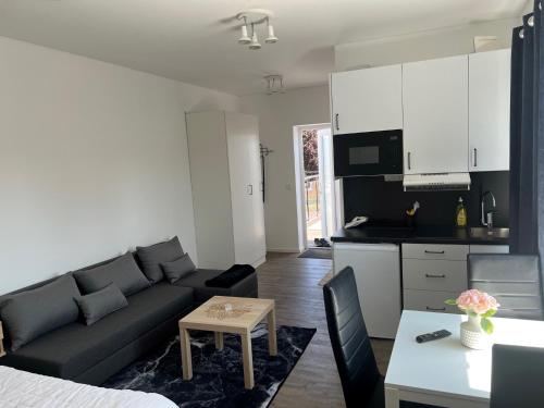 a living room with a couch and a kitchen at Solberga lägenhetshotell in Köpingsvik