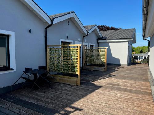 a patio with a white building and a wooden deck at Solberga lägenhetshotell in Köpingsvik
